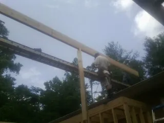 Carpenter setting a ridge beam over a new addition frame — Ice Dam Removal by Roofing Brothers in Wyckoff