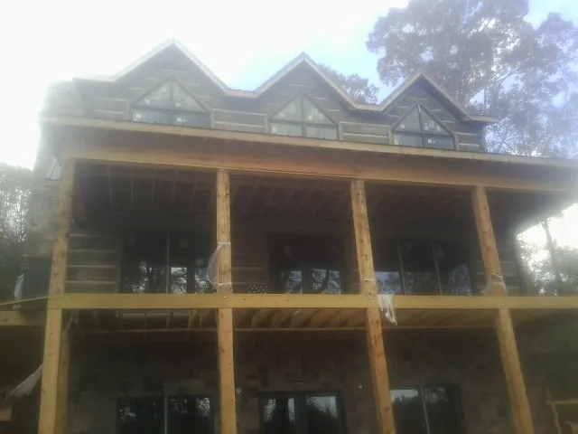 Dormers and porch framing on a large log home under construction — Roof Coating work by our crew in Wyckoff