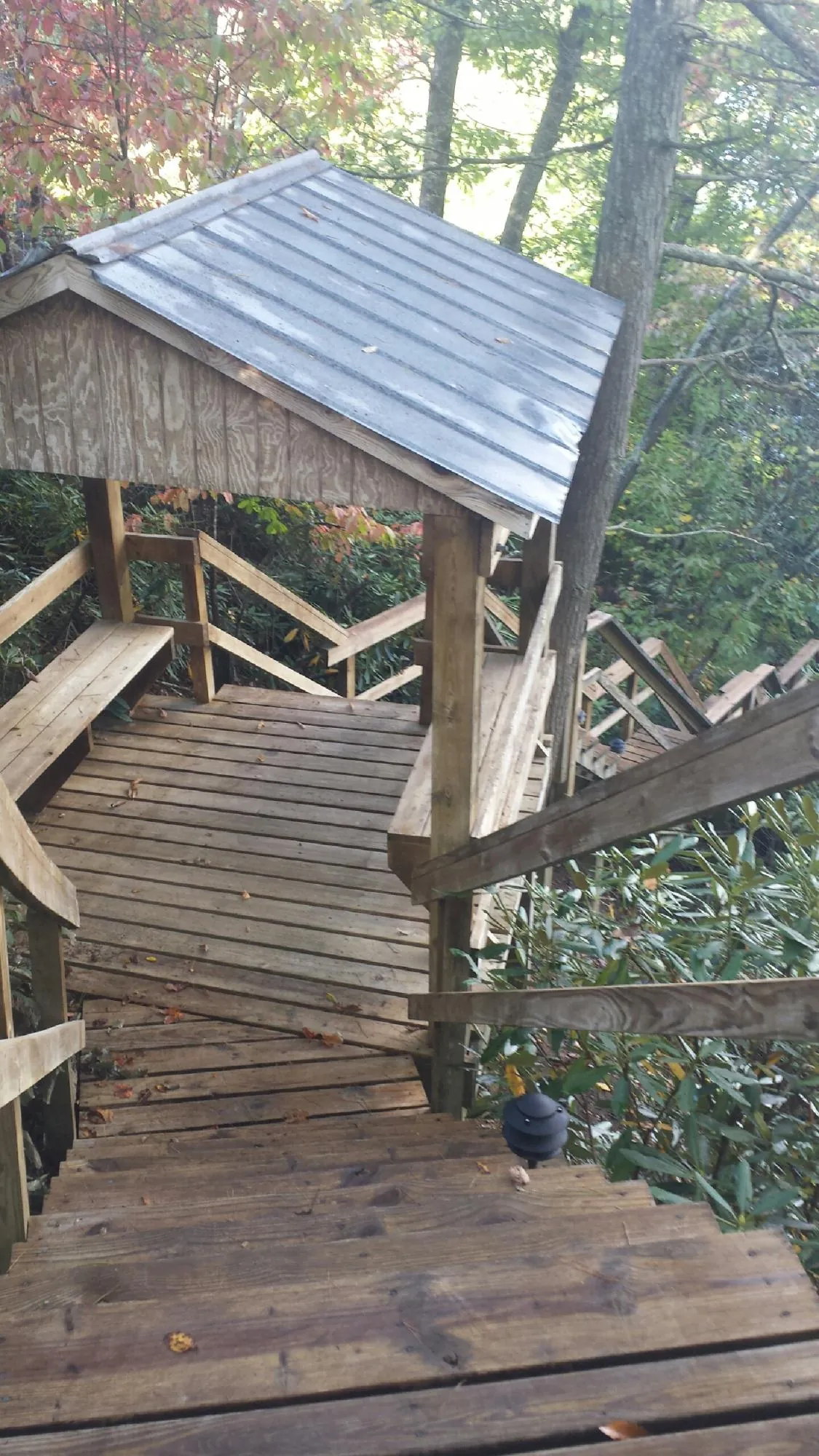 Metal roofed shelter over wooden steps on a wooded walkway — Skylight Repair & Installation work by our crew in Wyckoff